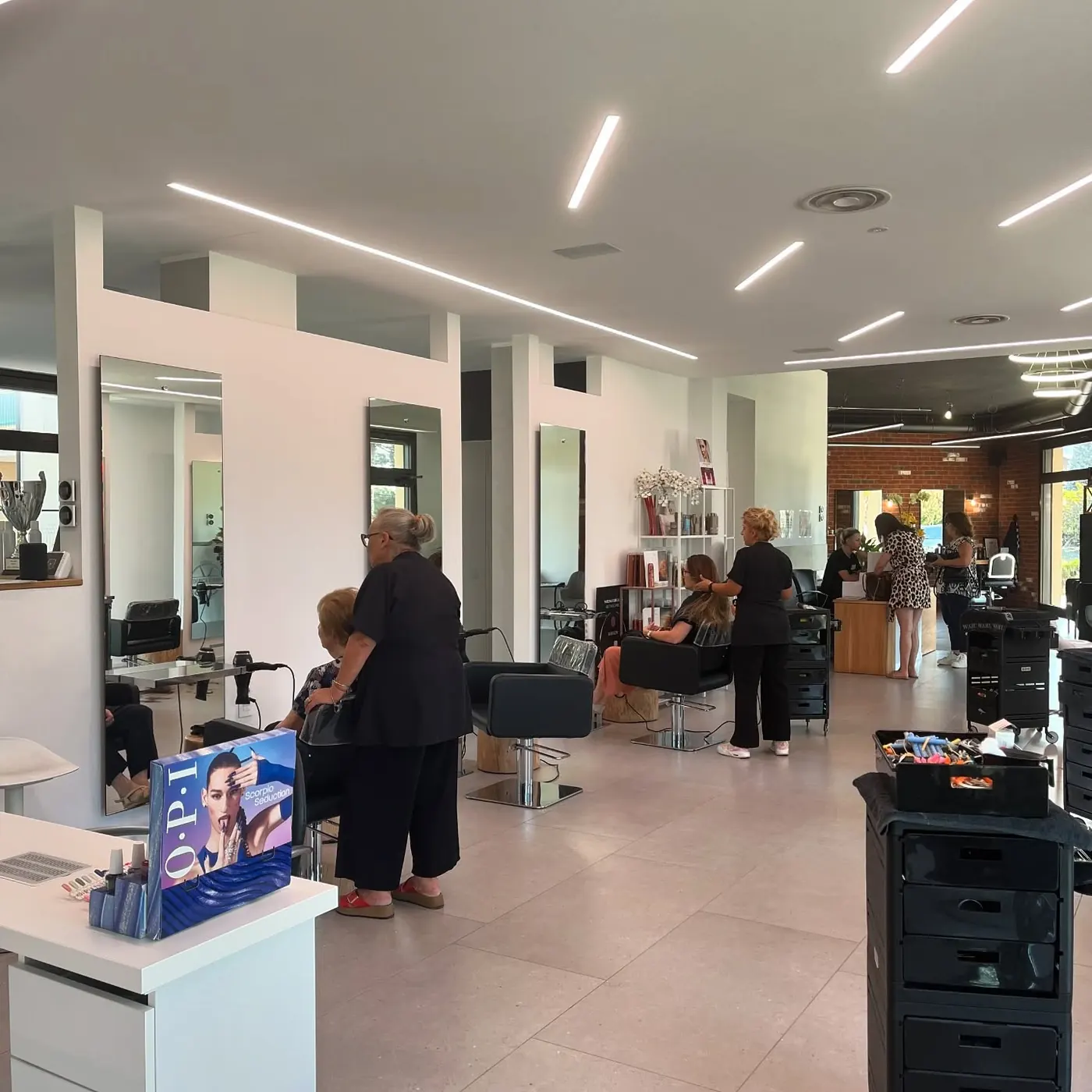 Il salone donna: lungo e luminoso, con specchi, poltrone nere e luci a soffitto