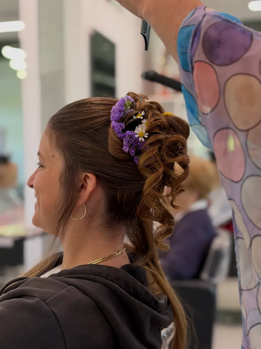 Raccolto da sposa con fiori viola tra i capelli