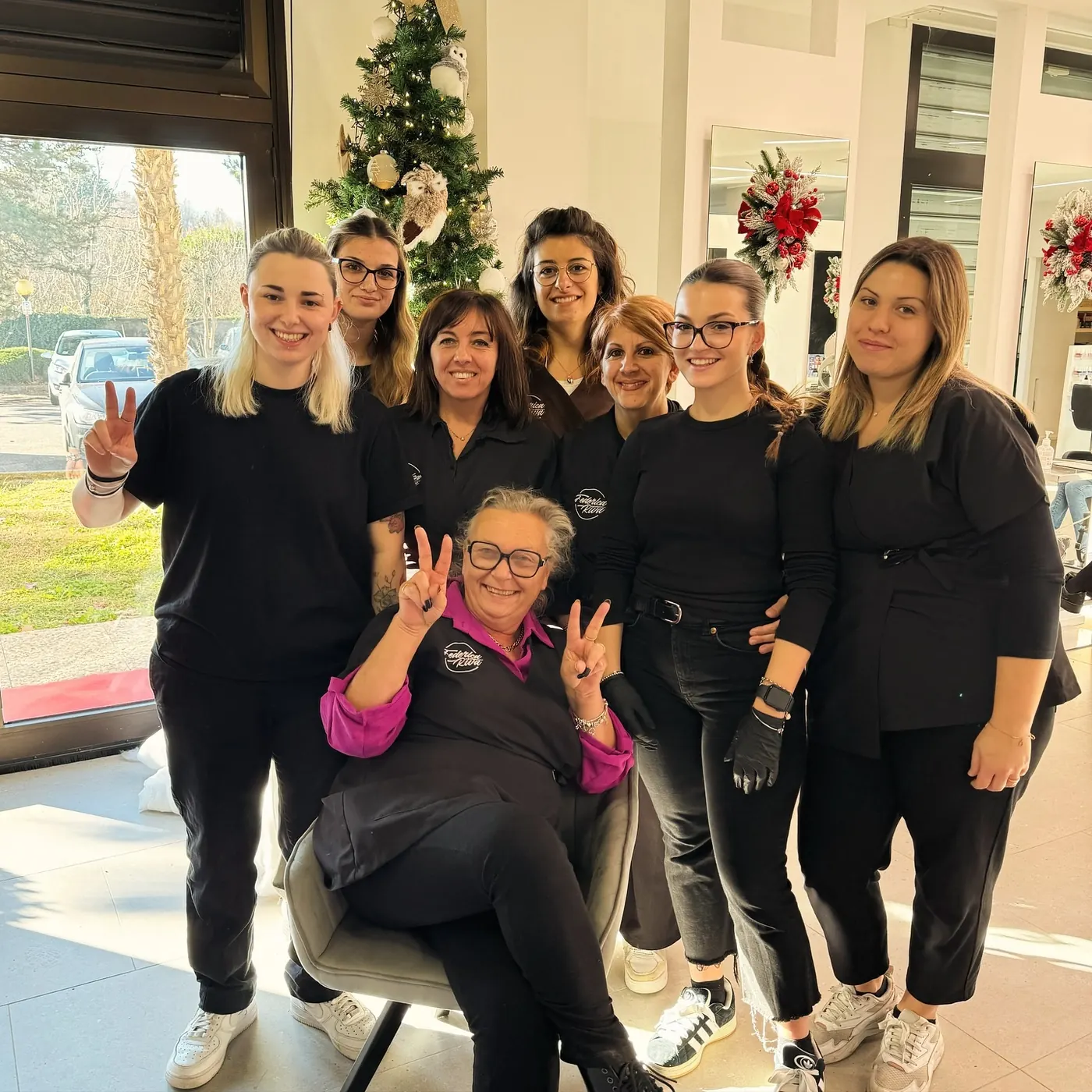 Lo staff del salone Federica & Anita, tutte in nero, sorridenti davanti all’albero di Natale